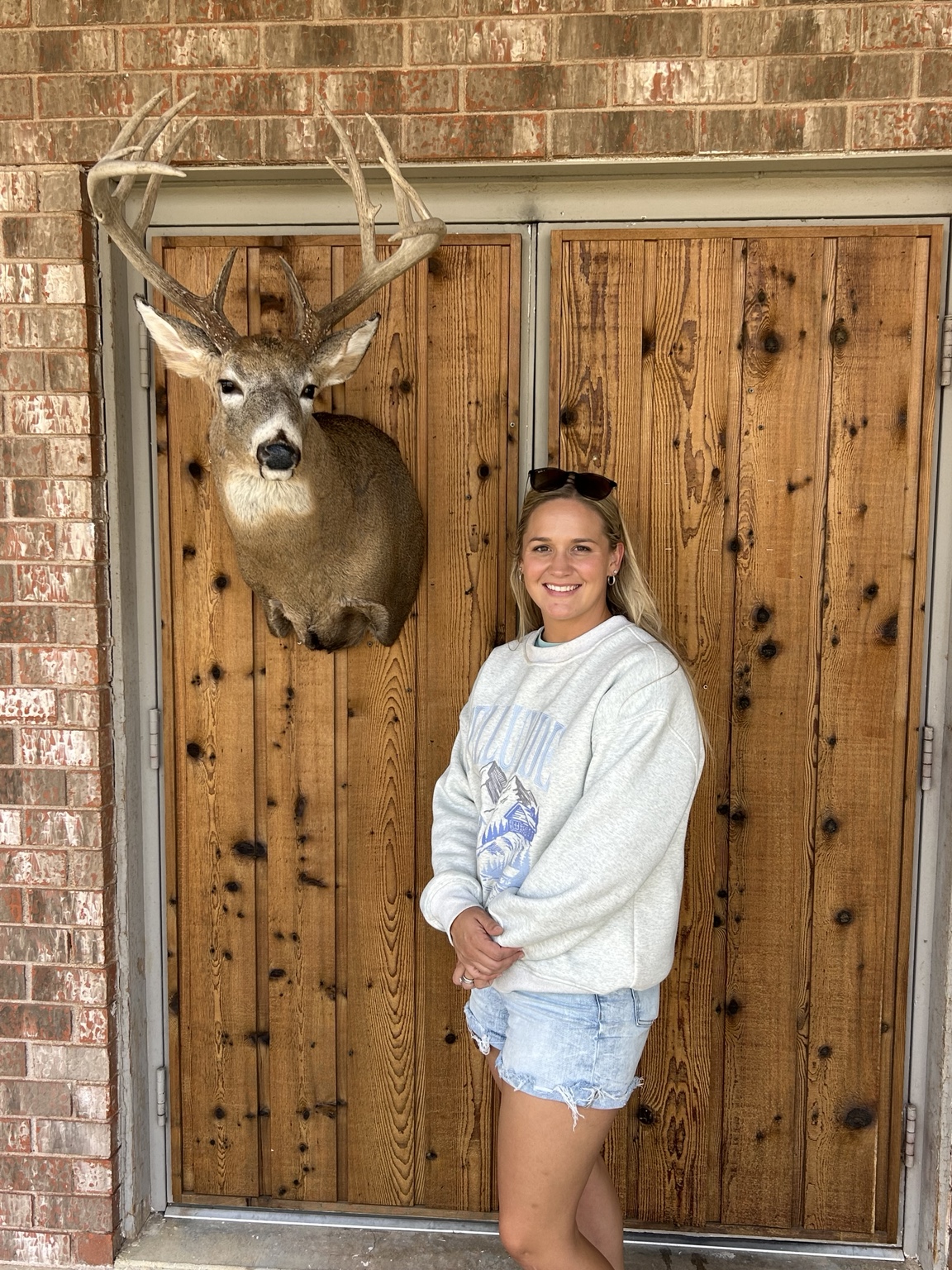 Montana standing beside a whitetail shoulder mount